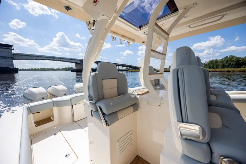  Yacht Photos Pics 2019 Scout 420 LXF boat interior with luxurious seating, under a clear blue sky near a bridge.