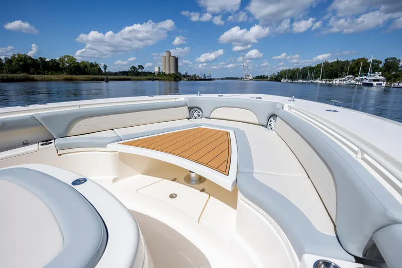  Yacht Photos Pics Luxurious 2019 Scout 420 LXF boat interior with elegant seating and table on a sunny day.