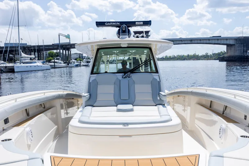  Yacht Photos Pics 2019 Scout 420 LXF boat on water near a bridge, featuring luxurious seating.