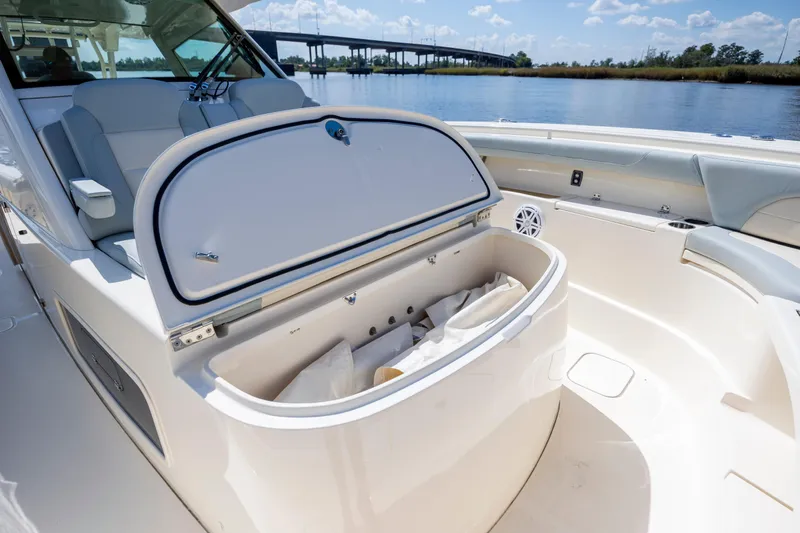  Yacht Photos Pics 2019 Scout 420 LXF boat interior with open storage compartment, near waterway and bridge.