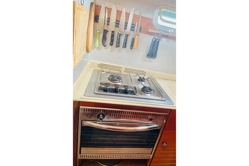 Macera Yacht Photos Pics Compact kitchen in 2008 Privilege 495 yacht with stove, oven, and knife set.