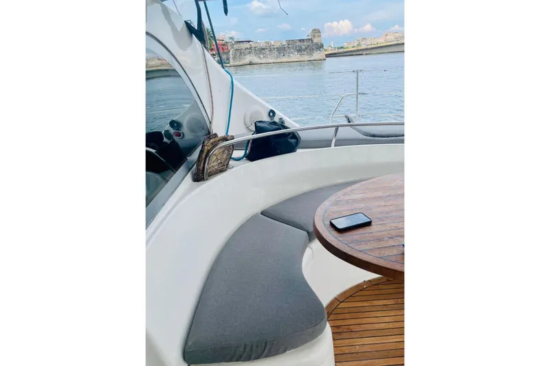 Macera Yacht Photos Pics Luxury Privilege 495 yacht interior with cushioned seating and wooden table, 2008 model.