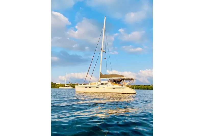 Macera Yacht Photos Pics Sailing catamaran Privilege 495, 2008 model, anchored on calm water under a blue sky.