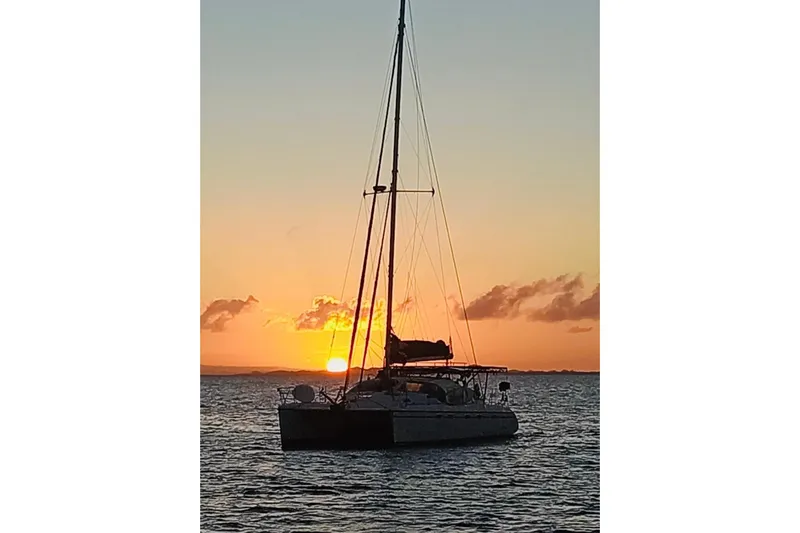 Macera Yacht Photos Pics Sailing catamaran Privilege 495 at sunset, 2008 model, on tranquil waters.