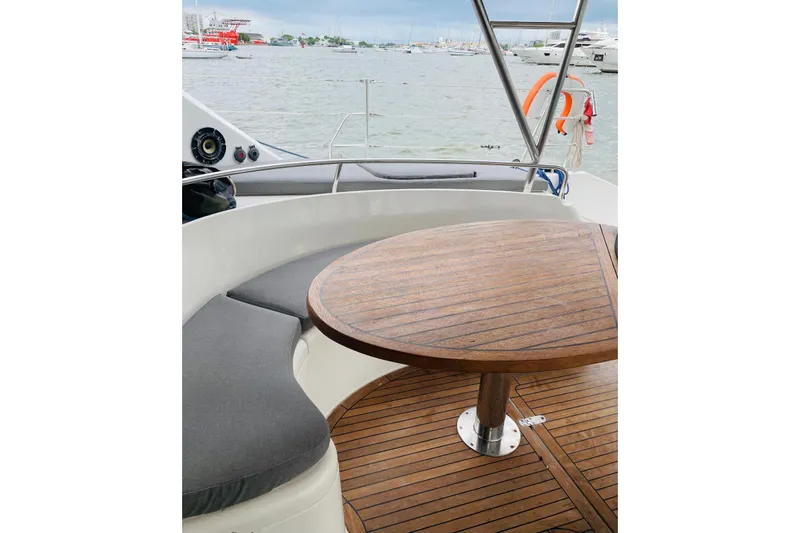 Macera Yacht Photos Pics Luxury Privilege 495 yacht deck with wooden table and cushioned seating, 2008 model.
