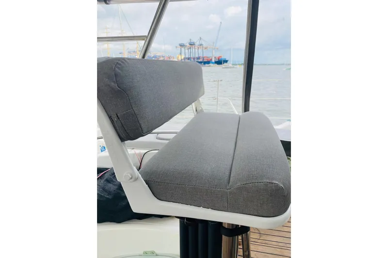 Macera Yacht Photos Pics Gray cushioned seat on 2008 Privilege 495 yacht, overlooking a harbor.