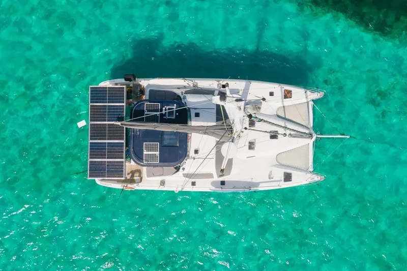 Macera Yacht Photos Pics Aerial view of 2008 Privilege 495 catamaran with solar panels on turquoise water.