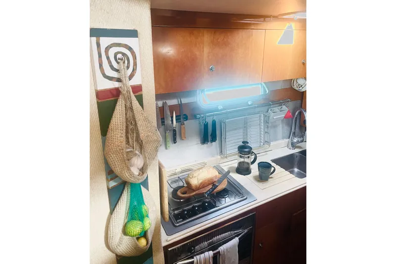 Macera Yacht Photos Pics Compact kitchen in 2008 Privilege 495 yacht with bread, coffee maker, and hanging storage.