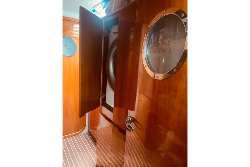 Macera Yacht Photos Pics Interior of 2008 Privilege 495 yacht with wooden cabinetry and porthole window.