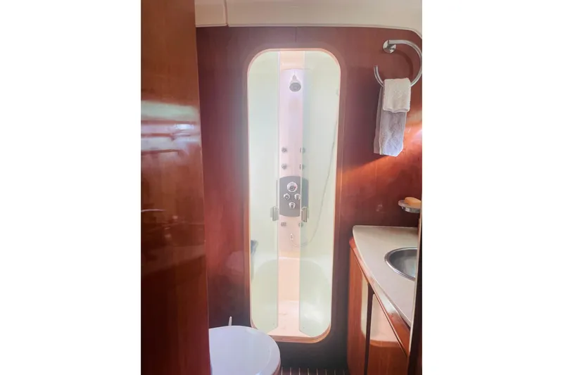 Macera Yacht Photos Pics Luxurious 2008 Privilege 495 yacht bathroom with shower, sink, and wooden cabinetry.