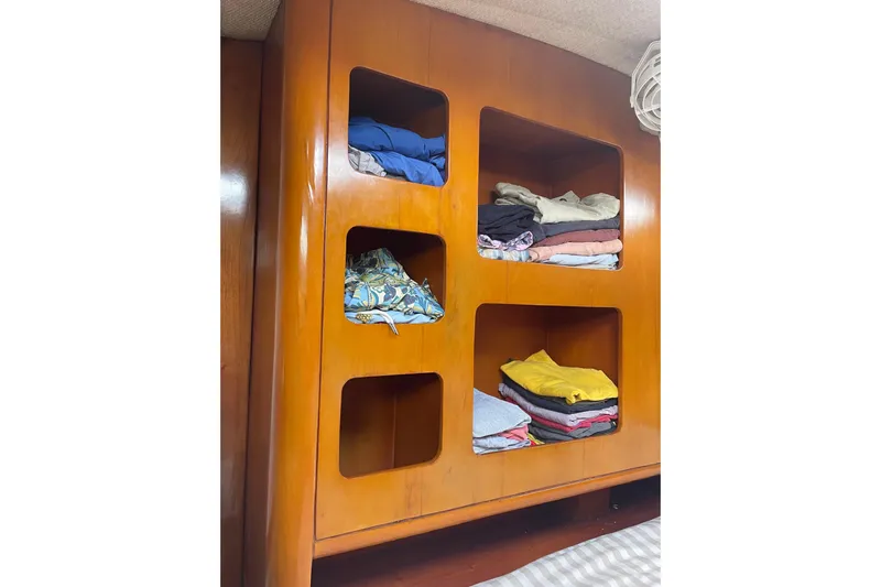 Macera Yacht Photos Pics Wooden cabinet with neatly folded clothes on a Privilege 495, 2008 model.