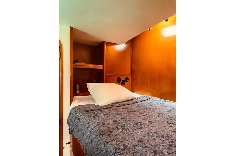 Macera Yacht Photos Pics Cozy cabin interior of 2008 Privilege 495 yacht with wooden finish and comfortable bedding.
