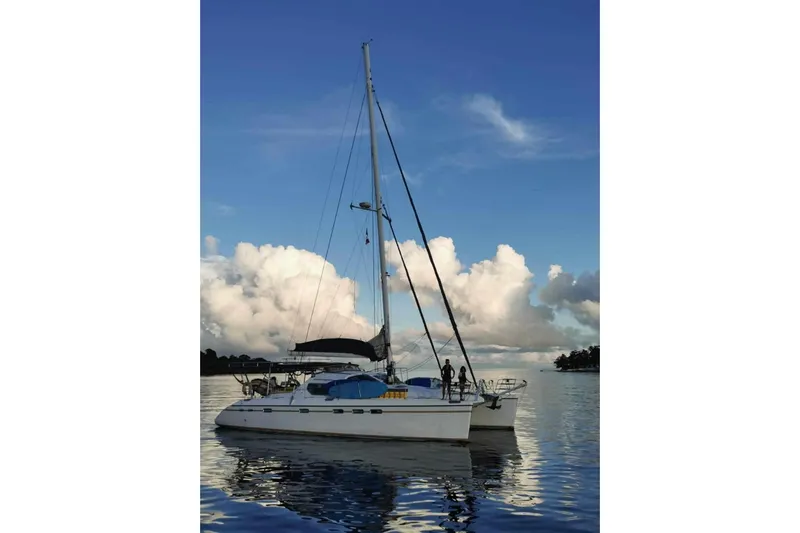 Macera Yacht Photos Pics Sailing catamaran Privilege 495, 2008 model, on calm water with cloudy sky.