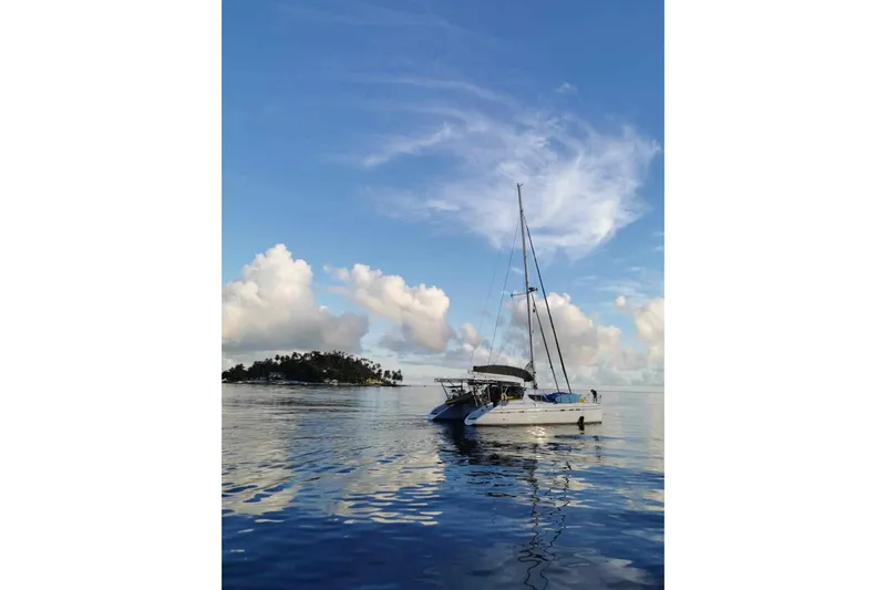 Macera Yacht Photos Pics Sailing catamaran Privilege 495, 2008 model, anchored near tropical island under blue sky.