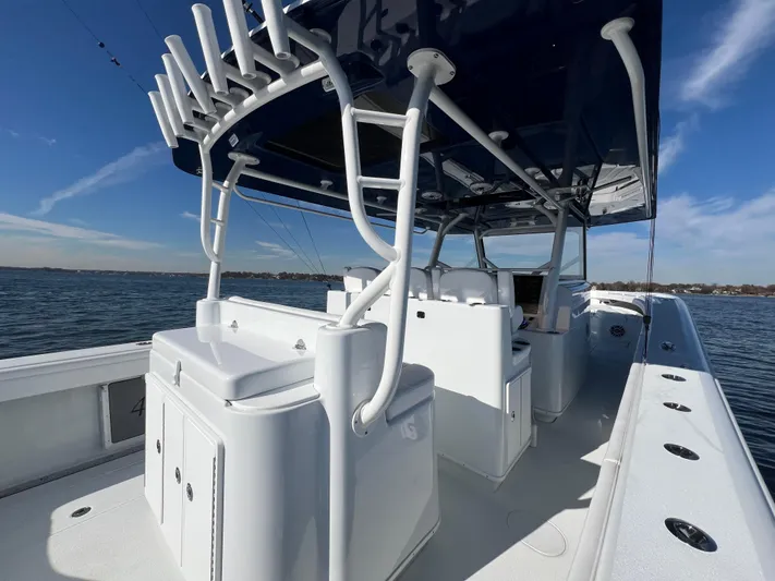  Yacht Photos Pics 2023 Yellowfin 42 Offshore boat with rod holders, sleek design, and spacious deck on open water.
