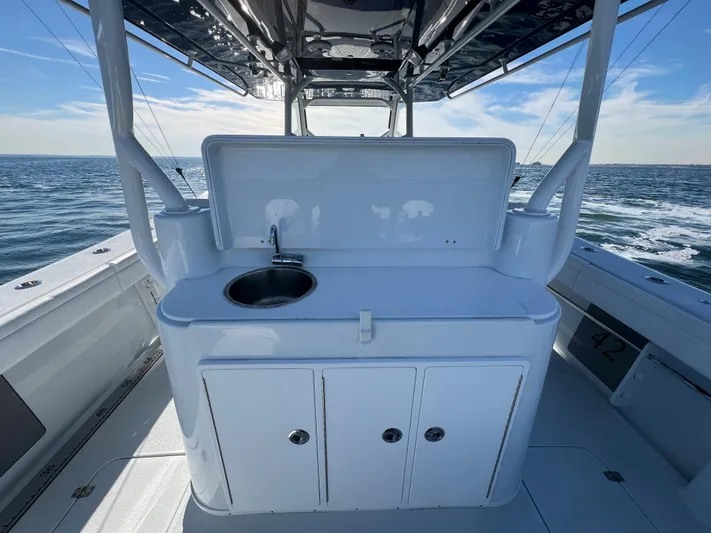  Yacht Photos Pics 2023 Yellowfin 42 Offshore boat with sink and storage, ocean backdrop.