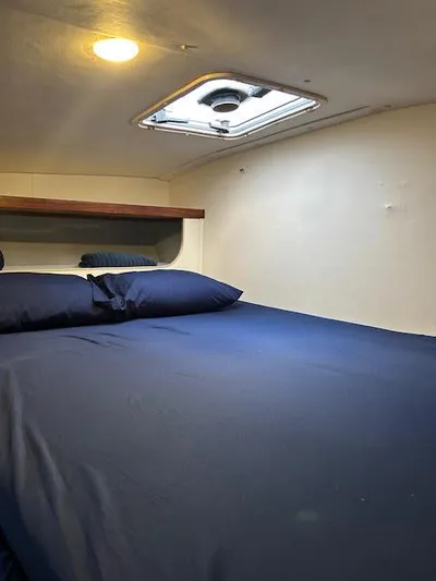  Yacht Photos Pics Cozy cabin interior of 1995 Lagoon TPI 37 with blue bedding and overhead hatch.
