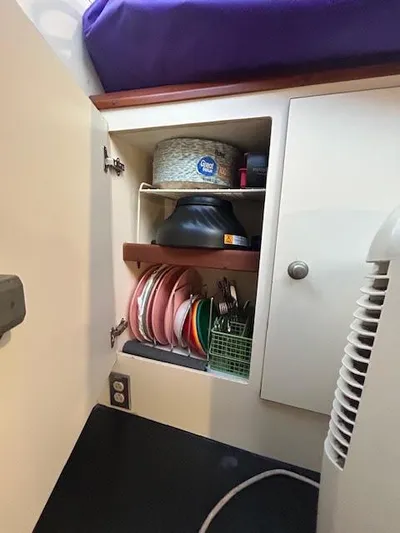  Yacht Photos Pics Cabinet interior with dishes and storage on a 1995 Lagoon TPI 37 boat.