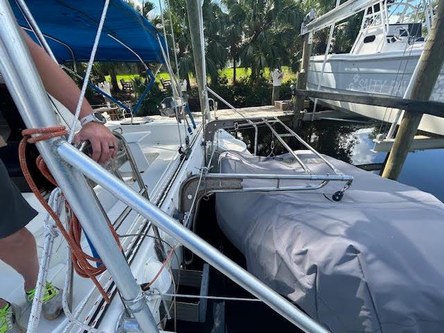 1995 Lagoon TPI 37 sailboat with covered dinghy, docked near palm trees.