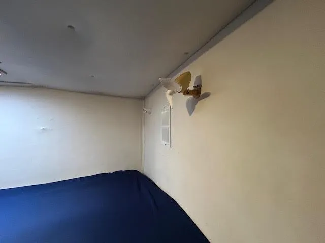  Yacht Photos Pics Interior cabin of 1995 Lagoon TPI 37 yacht with wall-mounted fan and blue bedding.