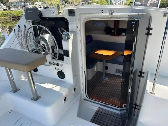  Yacht Photos Pics Cockpit and cabin view of 1995 Lagoon TPI 37 sailboat, featuring helm and seating area.