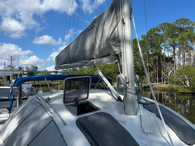  Yacht Photos Pics Sailboat Lagoon TPI 37, 1995 model, docked with trees and blue sky in the background.