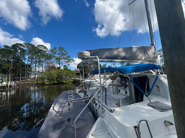 1995 Lagoon TPI 37 sailboat docked on a serene waterway under a clear blue sky.