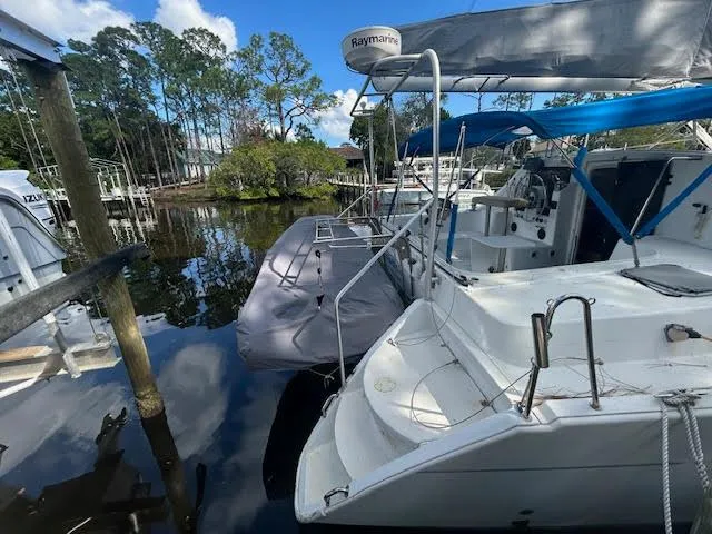  Yacht Photos Pics 1995 Lagoon TPI 37 catamaran docked in a serene marina setting.