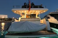 Luxury Astondoa A76 GLX yacht, upgraded to A80 GLX, docked at night with lights on.