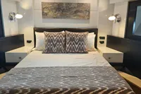 Luxurious bedroom interior on 2008 Astondoa A76 GLX yacht, featuring elegant bedding and modern lighting.
