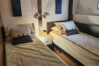 Luxurious twin bedroom in 2008 Astondoa A76 GLX yacht, featuring elegant bedding and modern lighting.