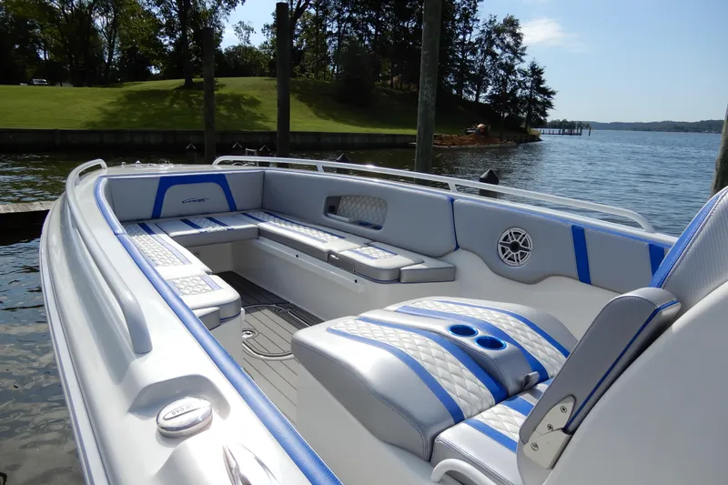  Yacht Photos Pics 2021 Concept 32' Open Deck boat with blue and white seating, docked by a scenic lake.