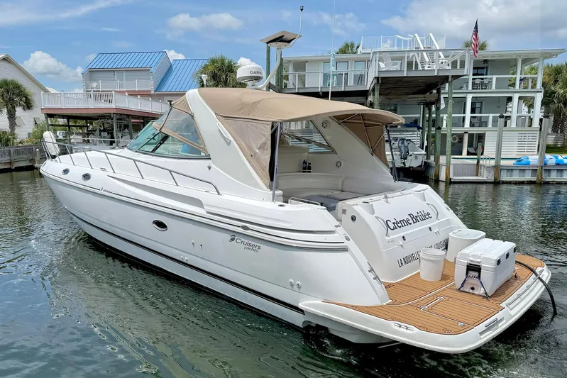 Creme Brulee Yacht Photos Pics 2001 Cruisers Yachts 4270 Express docked near waterfront homes.