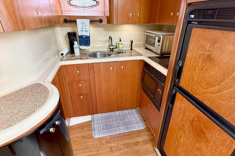 Creme Brulee Yacht Photos Pics 2001 Cruisers Yachts 4270 Express kitchen with wood cabinetry, sink, and appliances.