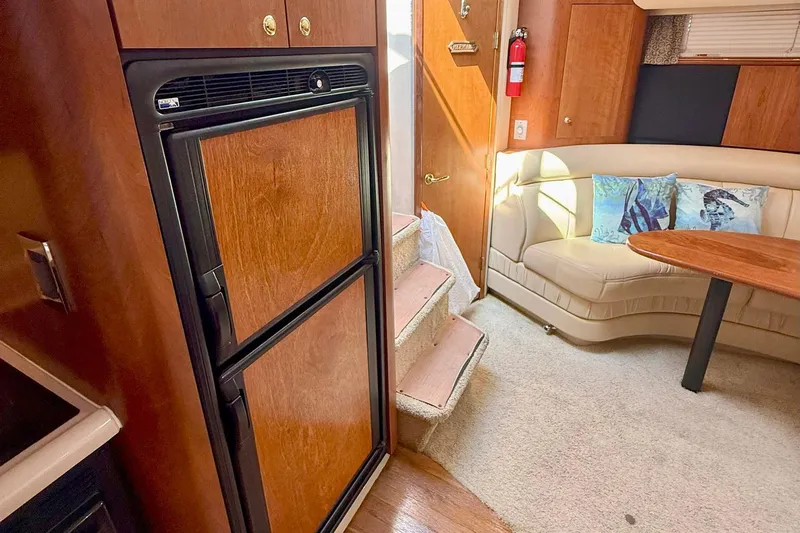 Creme Brulee Yacht Photos Pics Interior of 2001 Cruisers Yachts 4270 Express with fridge, seating, and wooden accents.