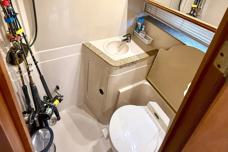 Creme Brulee Yacht Photos Pics Bathroom of 2001 Cruisers Yachts 4270 Express with fishing rods and compact amenities.