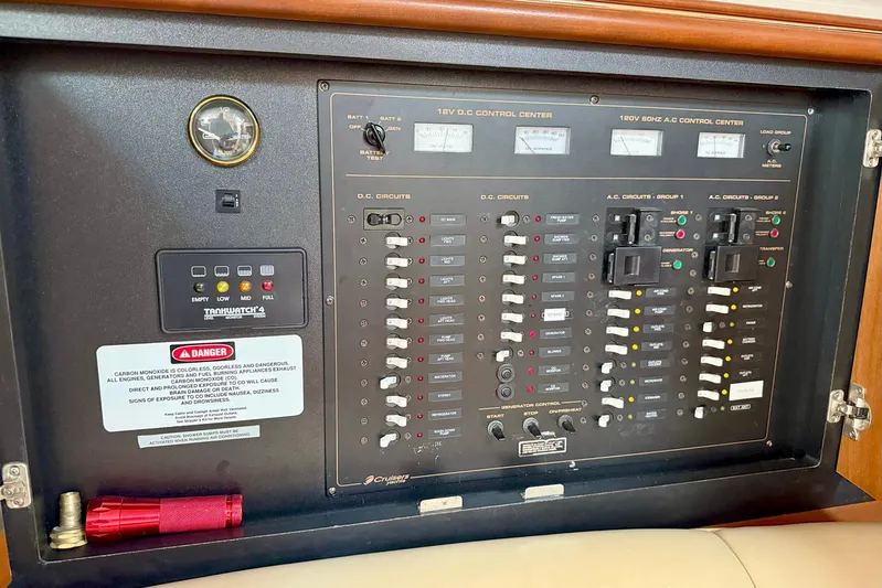 Creme Brulee Yacht Photos Pics Electrical control panel of 2001 Cruisers Yachts 4270 Express, featuring various circuit switches and gauges.