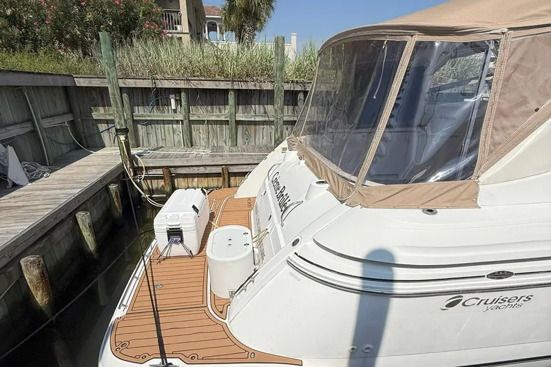 Creme Brulee Yacht Photos Pics 2001 Cruisers Yachts 4270 Express docked with tan canopy and wooden deck.