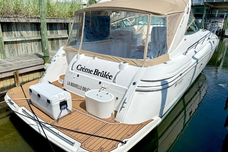 Creme Brulee Yacht Photos Pics 2001 Cruisers Yachts 4270 Express docked, featuring tan canopy and wooden deck.