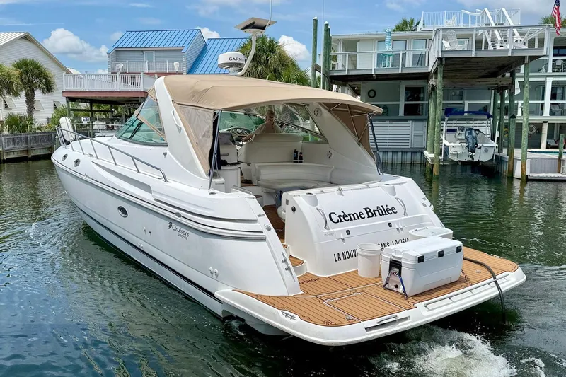 Creme Brulee Yacht Photos Pics 2001 Cruisers Yachts 4270 Express docked, featuring a beige canopy and wooden deck.