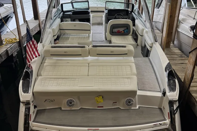  Yacht Photos Pics 2021 Cobalt R30 boat with spacious seating, docked near wooden pier.