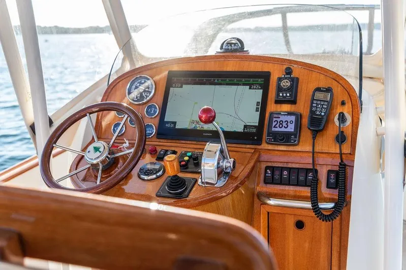 Wayfarer Yacht Photos Pics Hinckley Talaria 29C 2002 boat dashboard with navigation equipment and wooden steering wheel.