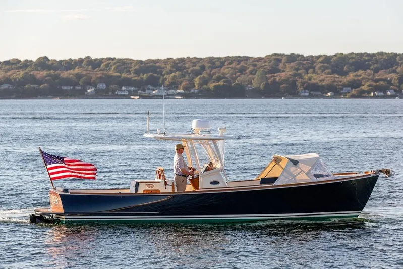 Wayfarer Yacht Photos Pics 2002 Hinckley Talaria 29C cruising on a serene lake with American flag.