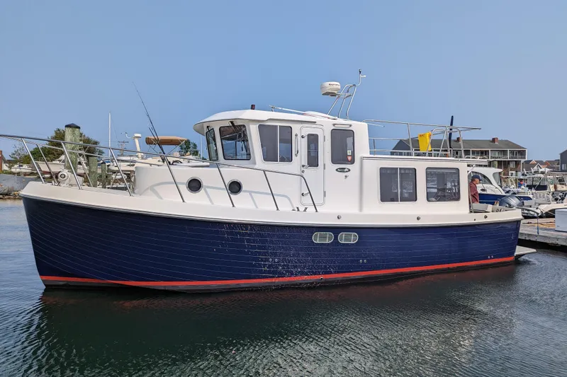 Emilie B Yacht Photos Pics 2003 American Tug 34 boat docked in a marina, featuring a blue hull and white cabin.