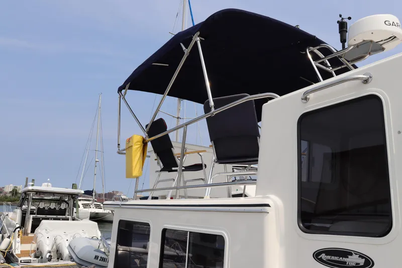 Emilie B Yacht Photos Pics 2003 American Tug 34 yacht docked with canopy and seating on deck.