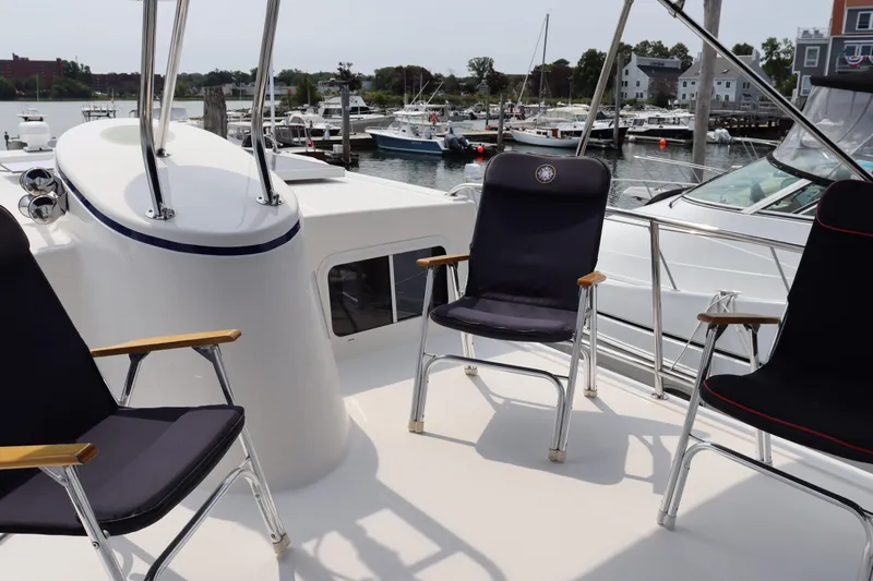Emilie B Yacht Photos Pics Deck seating on a 2003 American Tug 34, overlooking a marina with boats.