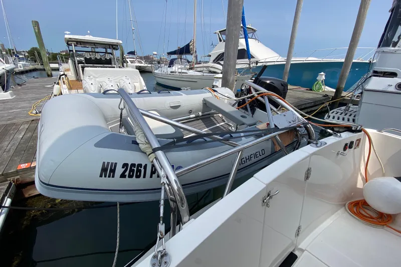 Emilie B Yacht Photos Pics 2003 American Tug 34 docked with inflatable dinghy and other boats in marina.
