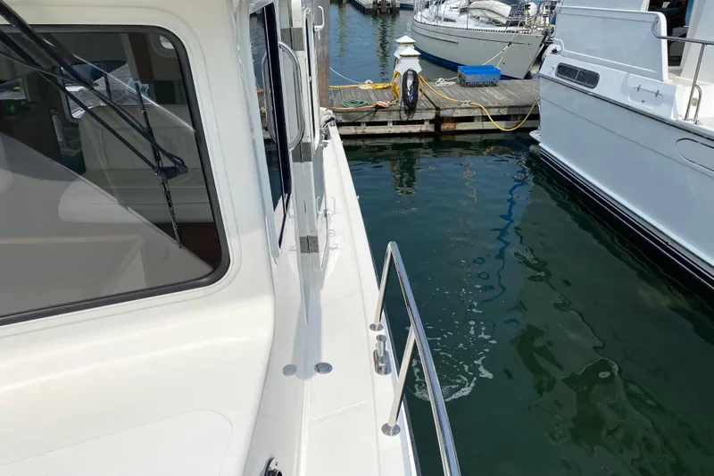 Emilie B Yacht Photos Pics 2003 American Tug 34 docked at marina, showing side deck and railing.