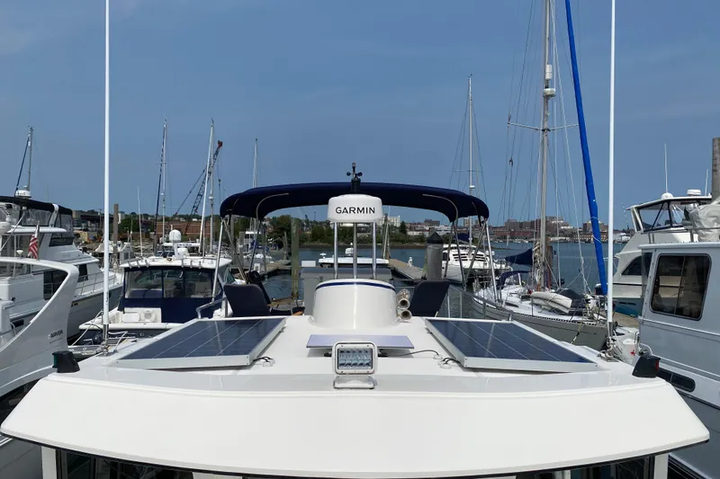 Emilie B Yacht Photos Pics American Tug 34 (2003) docked, featuring solar panels and Garmin equipment, surrounded by other boats.