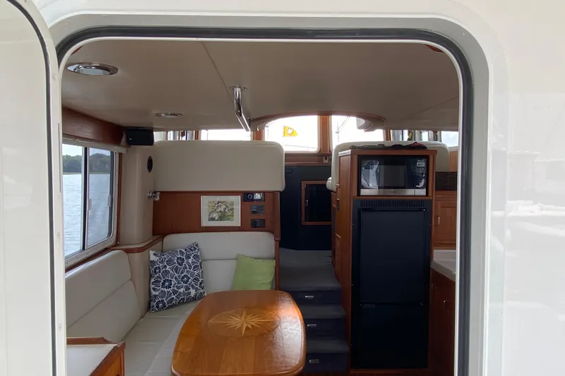 Emilie B Yacht Photos Pics Interior of a 2003 American Tug 34, featuring a cozy dining area and kitchenette.